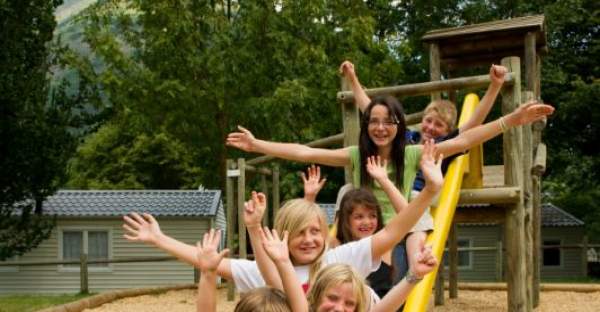 Groupe d'enfants sur le toboggan de l'aire de jeux au camping Le Hounta