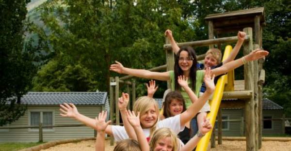 Groupe d'enfants sur le toboggan de l'aire de jeux au camping Le Hounta